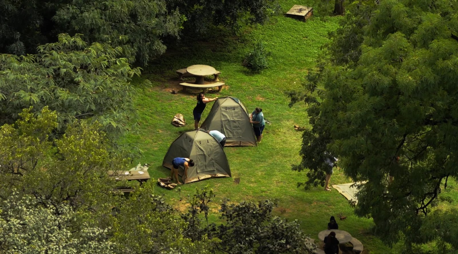 Aerial view of guests pitching tents on the Rest Camp campsite